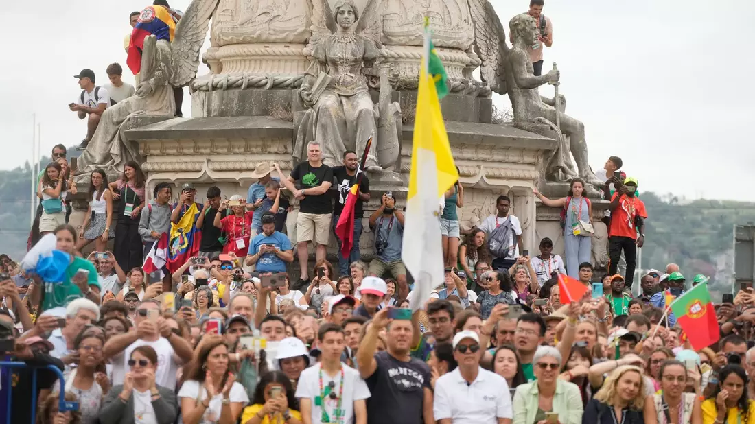 Menschen warten vor dem Präsidentenpalast auf die Ankunft des Papstes. Zehntausende Gläubige jubelten dem Pontifex zu und begrüßten ihn mit Fahnen und Postern. - Bild: Gregorio Borgia/AP/dpa