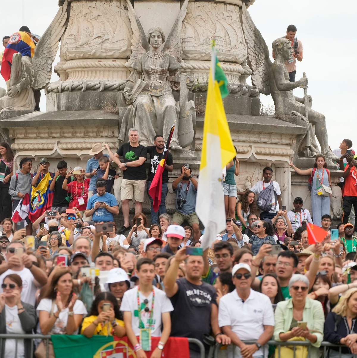 Menschen warten vor dem Präsidentenpalast auf die Ankunft des Papstes. Zehntausende Gläubige jubelten dem Pontifex zu und begrüßten ihn mit Fahnen und Postern. - Foto: Gregorio Borgia/AP/dpa