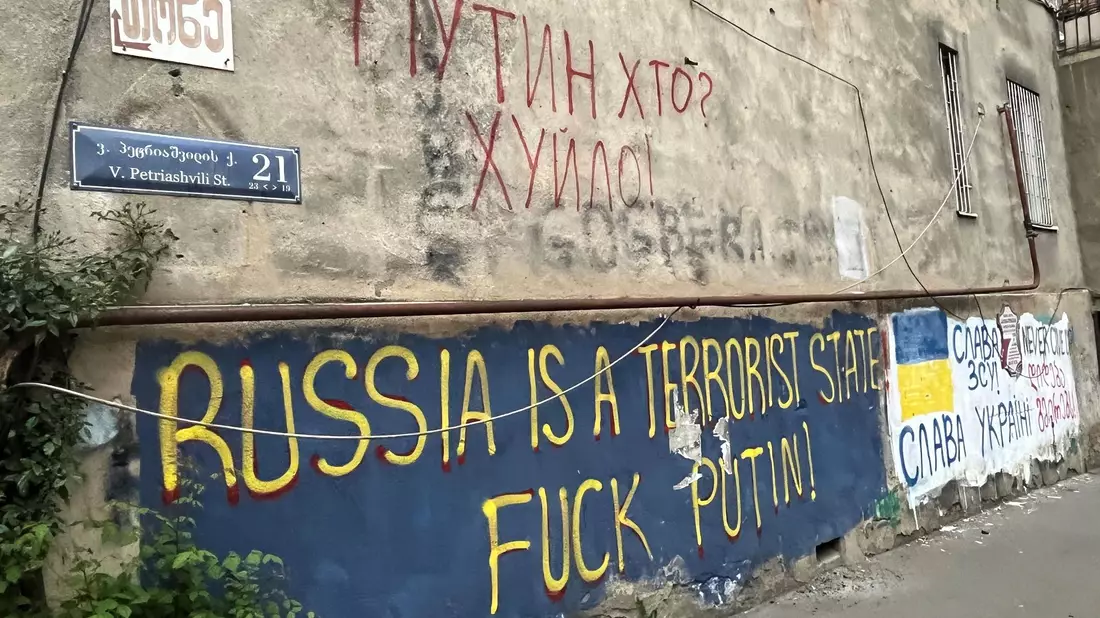 An einer Hauswand in einem Viertel der Hauptstadt Tiflis stehen auf Englisch und auf Ukrainisch antirussische Parolen, die den Krieg von Kremlchef Wladimir Putin gegen die Ukraine verurteilen. - Bild: Ulf Mauder/dpa