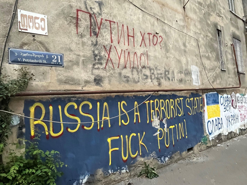An einer Hauswand in einem Viertel der Hauptstadt Tiflis stehen auf Englisch und auf Ukrainisch antirussische Parolen, die den Krieg von Kremlchef Wladimir Putin gegen die Ukraine verurteilen. - Foto: Ulf Mauder/dpa