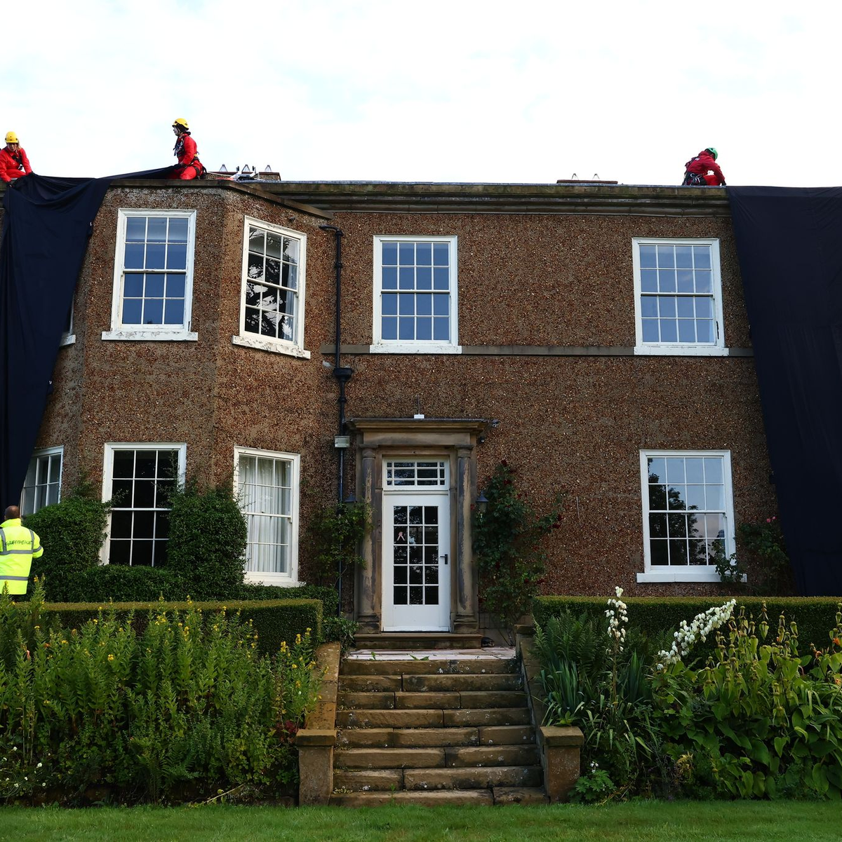 Greenpeace-Aktivisten während sie das Haus des britischen Premier verhüllen. - Foto: Luca Marino/Greenpeace/PA/dpa