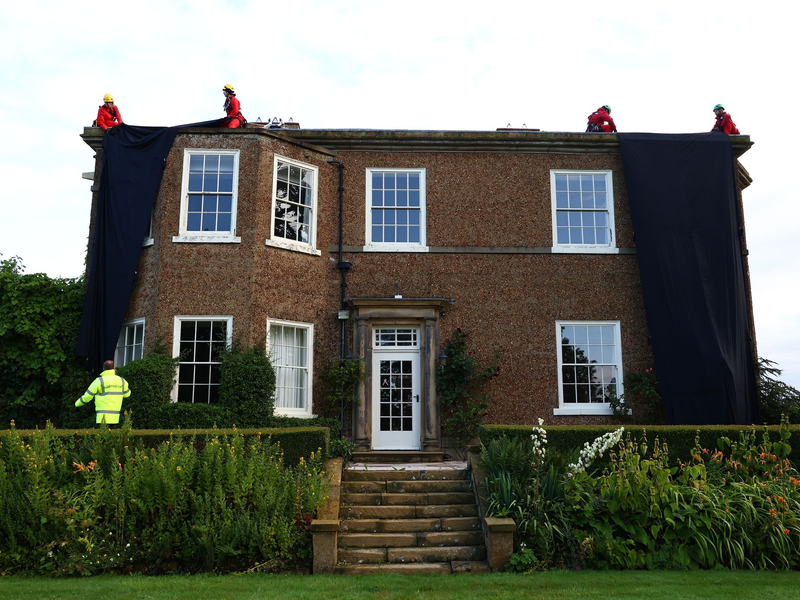 Greenpeace-Aktivisten während sie das Haus des britischen Premier verhüllen. - Foto: Luca Marino/Greenpeace/PA/dpa