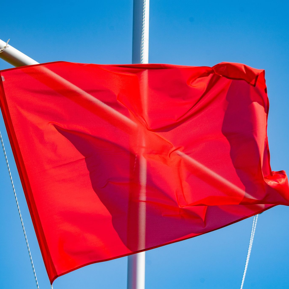 Die rote Flagge am Turm der DLRG in Binz signalisiert, dass das Baden verboten ist. - Foto: Stefan Sauer/dpa