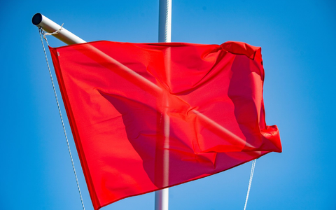 Die rote Flagge am Turm der DLRG in Binz signalisiert, dass das Baden verboten ist. - Foto: Stefan Sauer/dpa