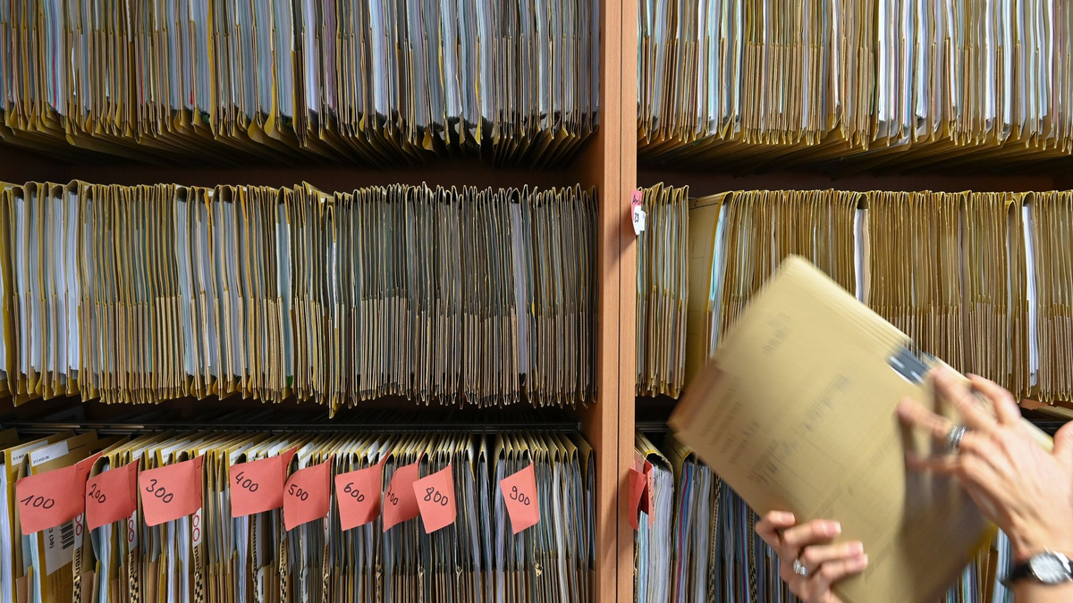 Eine Mitarbeiterin des Amtsgerichts Frankfurt greift an einem Regal nach einer Gerichtsakte. Der digitale Wandel in der hessischen Justiz ist mit der Einführung der E-Akte ein weiteres Stück vorangekommen. - Foto: Arne Dedert/dpa