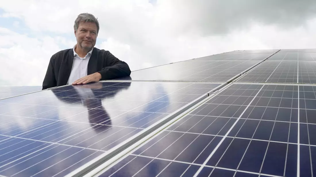 Robert Habeck (Bündnis 90/Die Grünen) steht zwischen Solarmodulen während seines Besuchs im Solarpark Klein Rheide. - Bild: Marcus Brandt/dpa