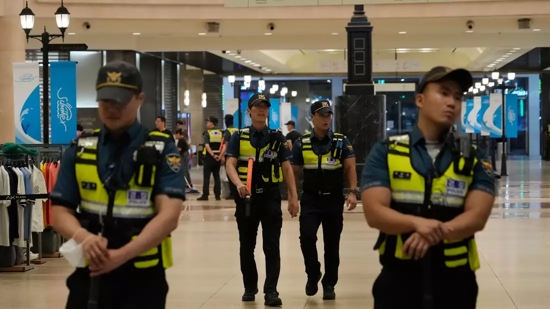 Polizisten patrouillieren am Tatort in der Nähe einer U-Bahn-Station in Seongnam. - Bild: Ahn Young-joon/AP/dpa