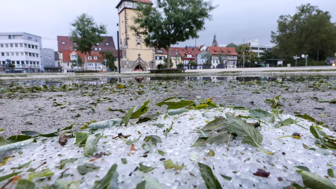 Hagelkörner und vom Sturm abgerissene Blätter liegen in Reutlingen auf dem Boden. - Bild: Thomas Warnack/dpa
