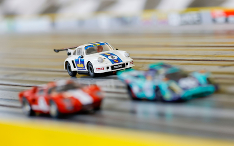Carrera-Autos fahren auf der Rennstrecke im Rennbahn-Center Franken im bayerischen Heroldsberg. - Foto: Daniel Löb/dpa