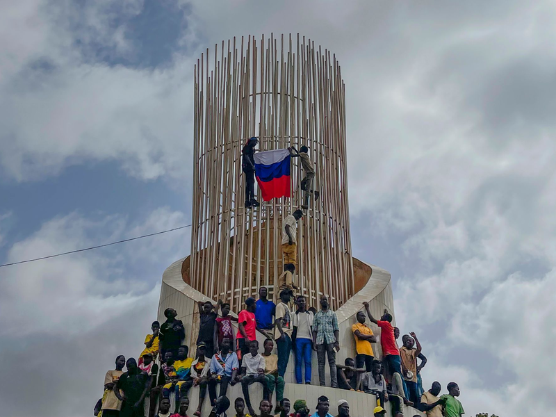 Anhänger der Militärjunta im Niger stehen an einem Kreisverkehr in Niamey und halten Wache. - Foto: Sam Mednick/AP/dpa