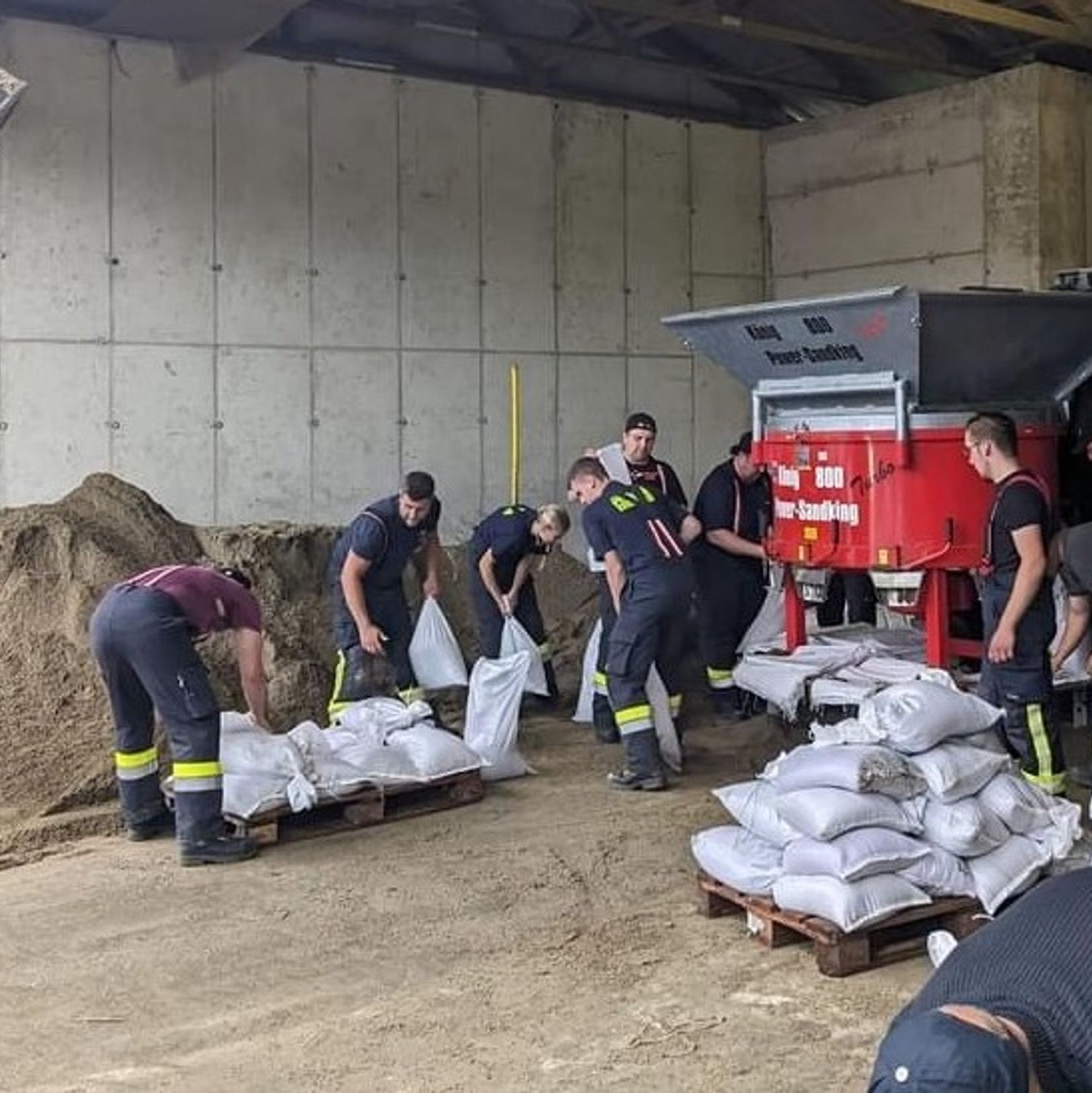 Mitarbeiter der Feuerwehr befüllen in Deutschlandsberg (Steiermark) Sandsäcke im Kampf gegen die Überflutungen in der Gegend. - Foto: -/BFVMZ/APA/dpa