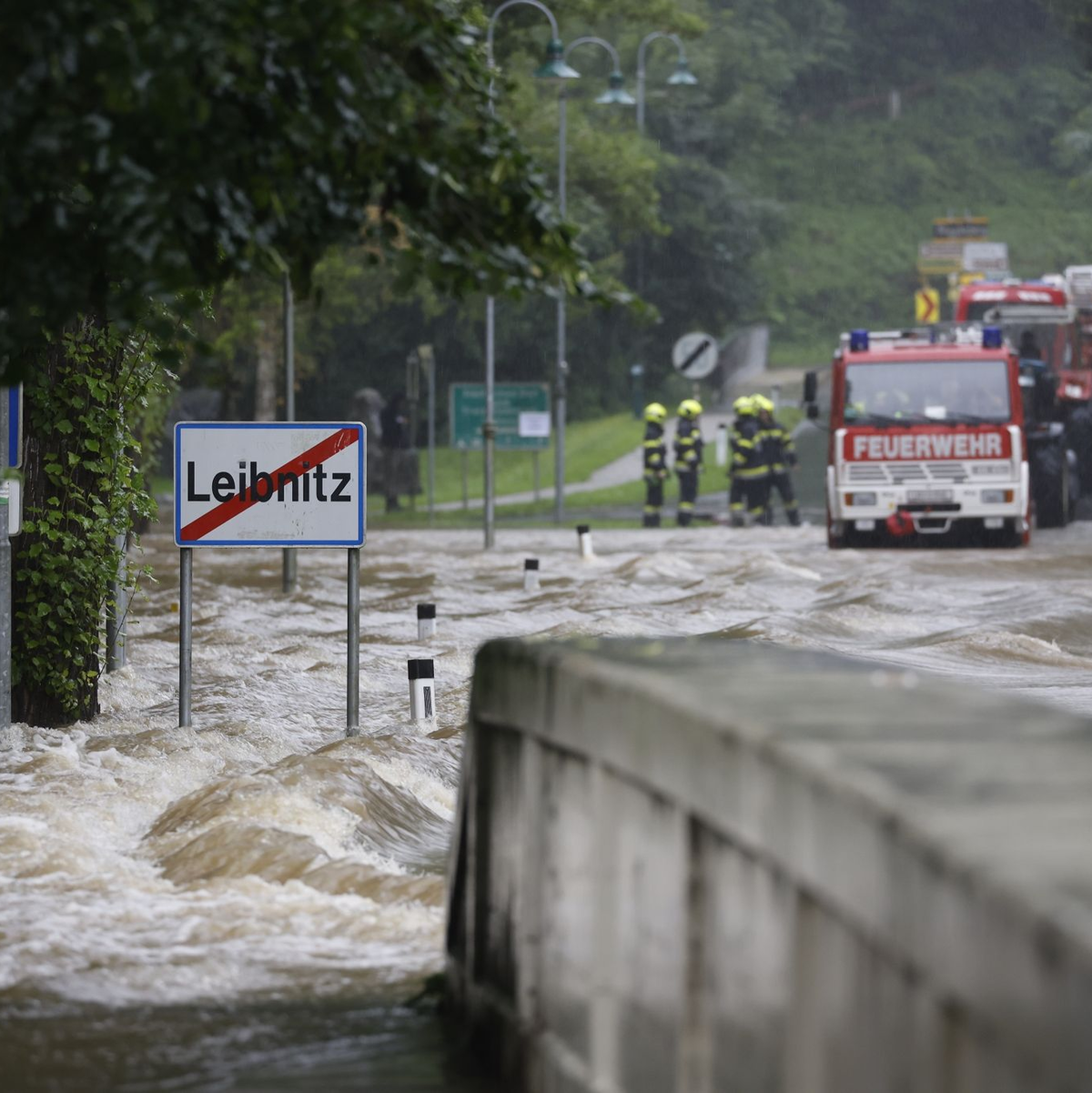 Feuerwehrwagen stehen vor einer überfluteten Brücke über die Sulm am Ortsausgang von Leibnitz in der Steiermark. - Foto: Erwin Scheriau/APA/dpa