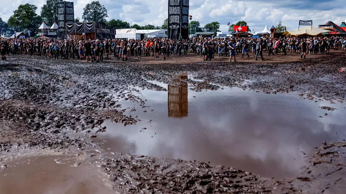 Das Wetter ist besser geworden, aber noch immer überziehen Schlammpfützen das Festival-Gelände in Wacken. - Bild: Axel Heimken/dpa