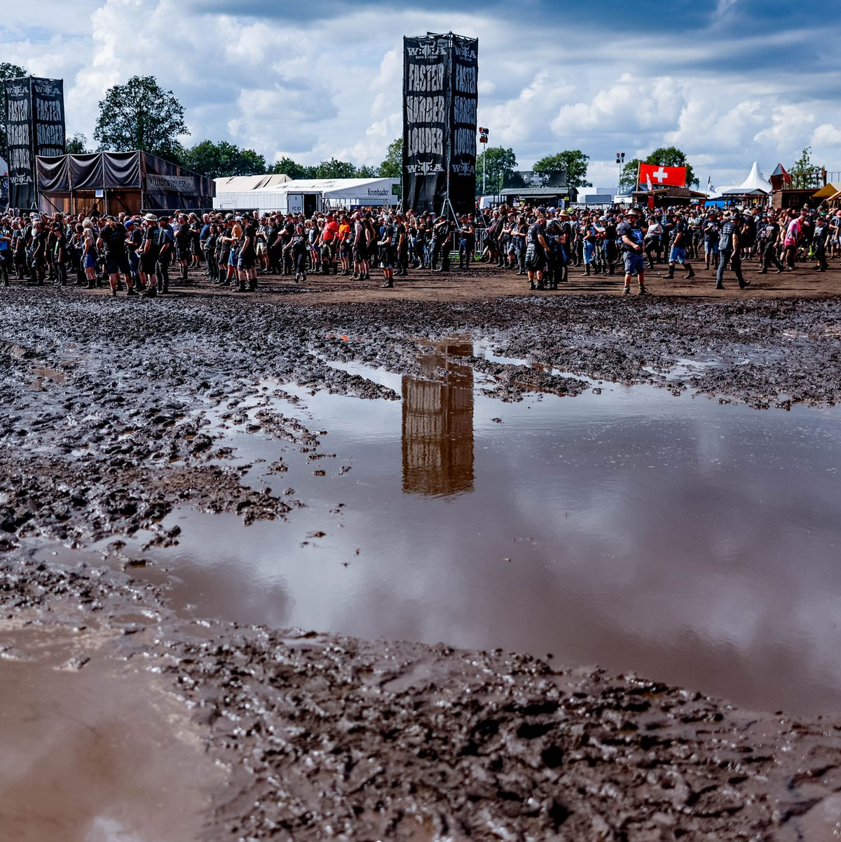 Das Wetter ist besser geworden, aber noch immer überziehen Schlammpfützen das Festival-Gelände in Wacken. - Foto: Axel Heimken/dpa