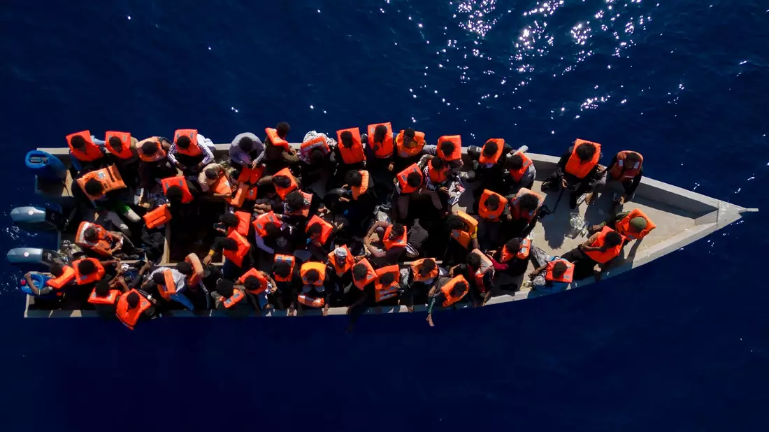 Aus Eritrea, Libyen und dem Sudan geflüchtete Menschen sitzen in einem Holzboot im Mittelmeer, etwa 30 Meilen nördlich von Libyen. - Bild: Joan Mateu Parra/AP/dpa