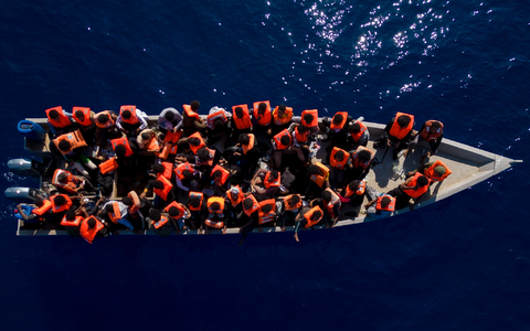 Aus Eritrea, Libyen und dem Sudan geflüchtete Menschen sitzen in einem Holzboot im Mittelmeer, etwa 30 Meilen nördlich von Libyen. - Foto: Joan Mateu Parra/AP/dpa