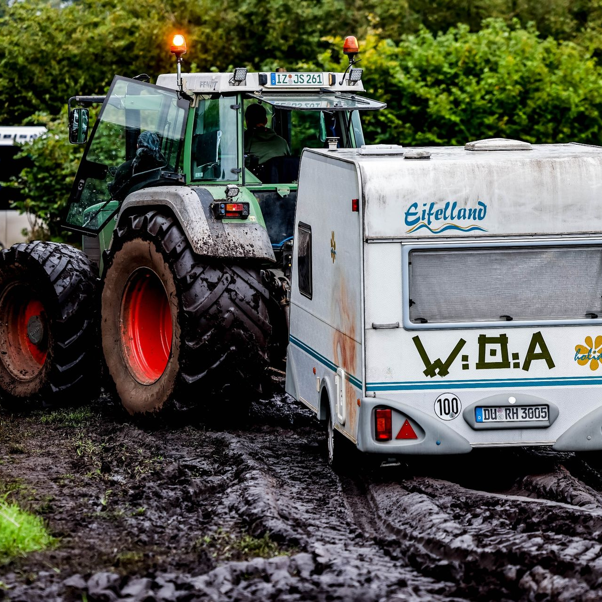 Ab durch den Schlamm: Ein Traktor zieht einen Wohnwagen vom Campinggelände des Wacken Open Air. - Foto: Axel Heimken/dpa