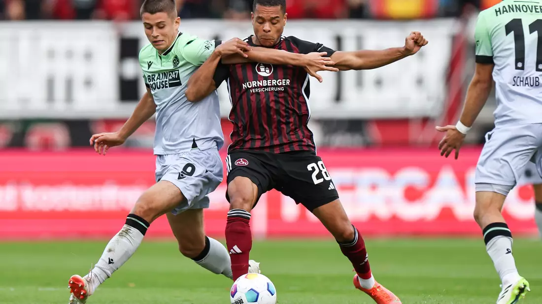 Nürnbergs Jan Gyamerah (M) und Hannovers Nicolo Tresoldi teilten sich mit ihren Teams die Punkte. - Bild: Daniel Karmann/dpa