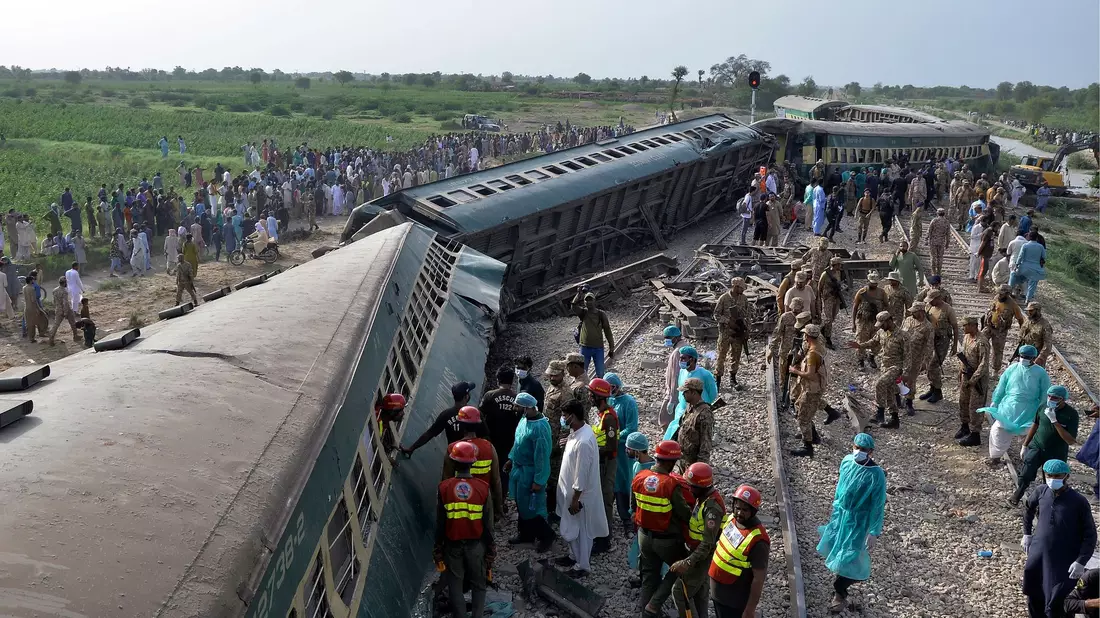 Rettungskräfte und Soldaten versuchen nach dem Unglück in der südpakistanischen Provinz Sindh, Menschen aus dem entgleisten Zug zu befreien. - Bild: Pervez Masih/AP/dpa