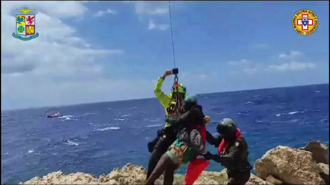Das von der italienischen Bergwacht zur Verfügung gestellte Videostandbild zeigt eine Rettungsaktion in einer unwegsamen Bucht auf Lampedusa. - Bild: Italy Alpine Rescue/Italian Alpine Rescue/AP/dpa