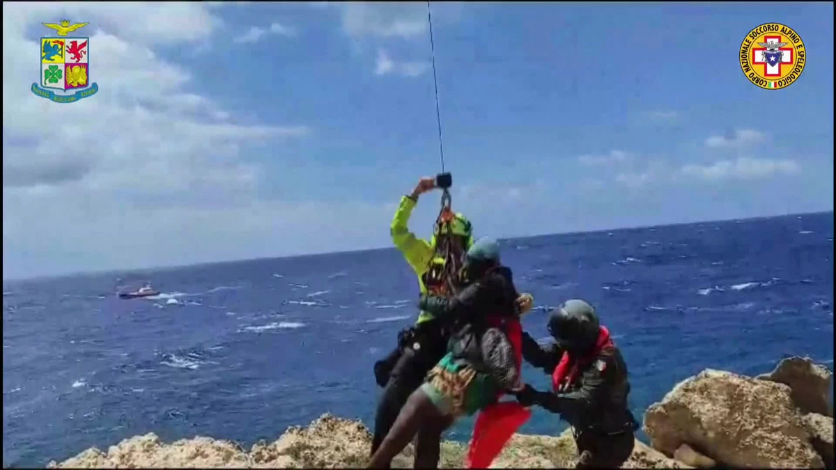 Das von der italienischen Bergwacht zur Verfügung gestellte Videostandbild zeigt eine Rettungsaktion in einer unwegsamen Bucht auf Lampedusa. - Foto: Italy Alpine Rescue/Italian Alpine Rescue/AP/dpa