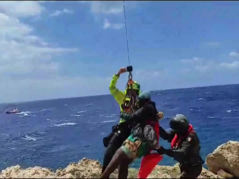 Das von der italienischen Bergwacht zur Verfügung gestellte Videostandbild zeigt eine Rettungsaktion in einer unwegsamen Bucht auf Lampedusa. - Foto: Italy Alpine Rescue/Italian Alpine Rescue/AP/dpa
