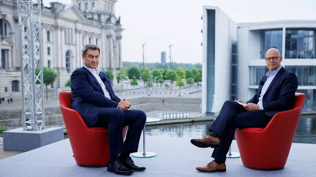 CSU-Chef Markus Söder (l) stand ARD-Journalist Matthias Deiß im Sommerinterview Rede und Antwort. - Bild: Carsten Koall/dpa