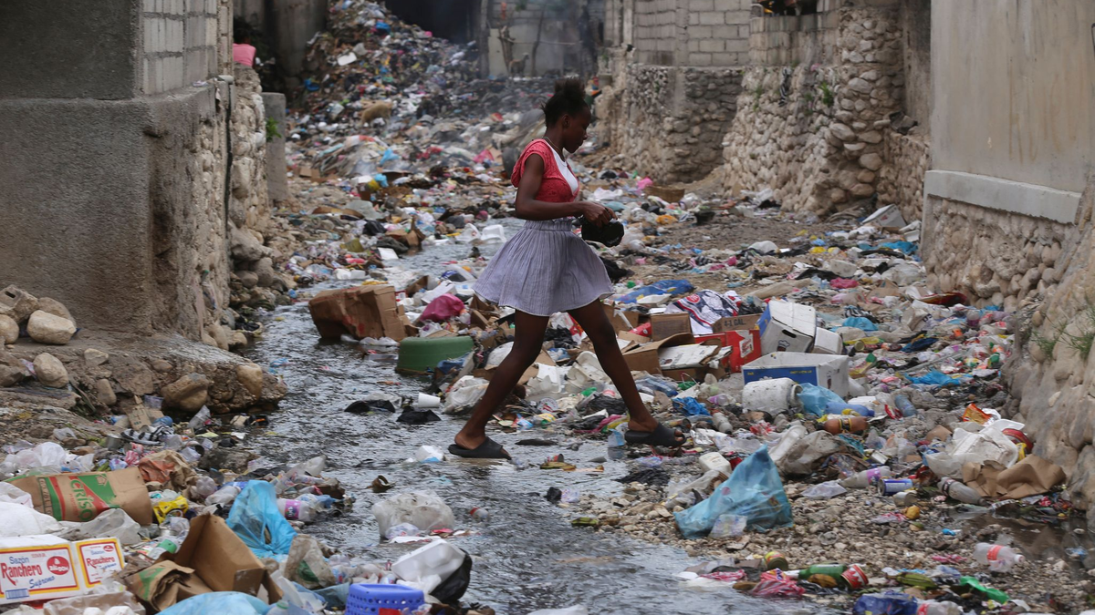 Ein Mädchen geht durch eine mit Müll gefüllte Häuserschlucht in Port-au-Prince. Bewaffnete Gruppen entführen dort zunehmend Kinder und Frauen - in den meisten Fällen zu finanziellen oder taktischen Zwecken. - Foto: Odelyn Joseph/AP