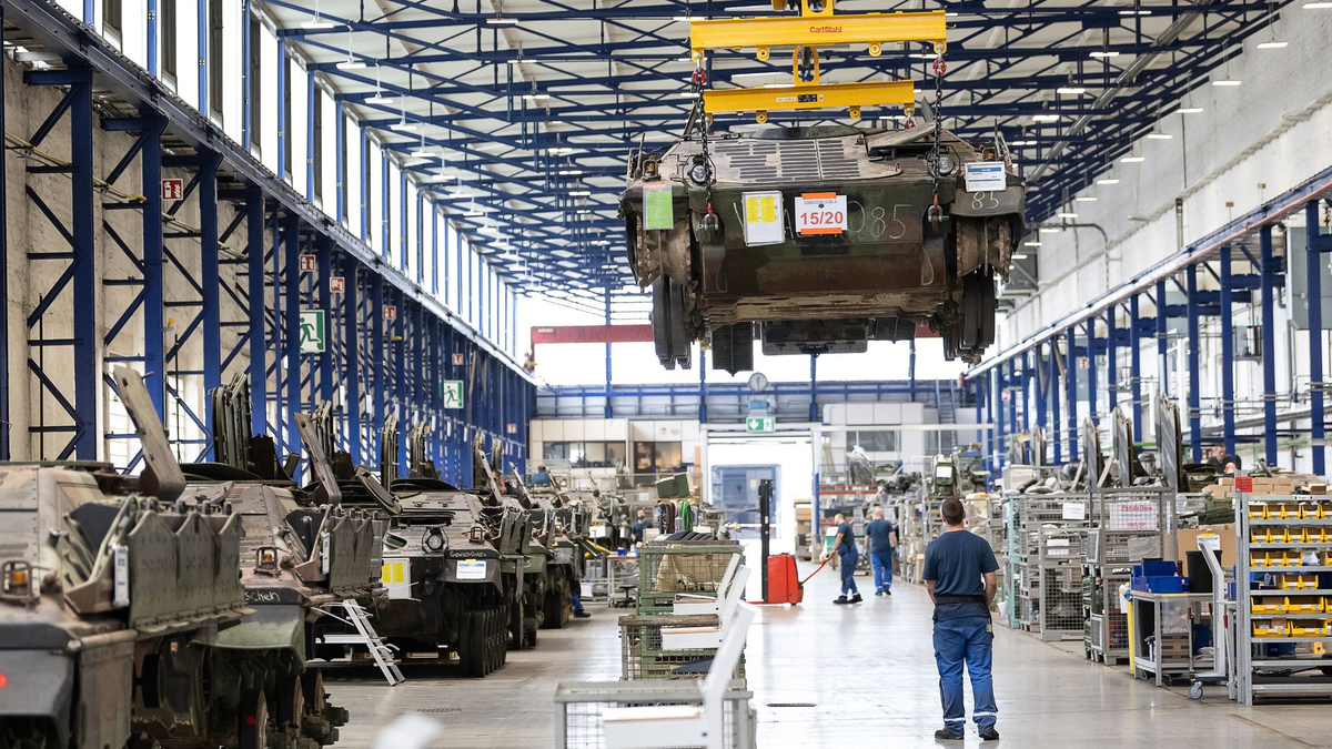 Ein Panzer vom Typ Marder schwebt in der Fertigungshalle von Rheinmetall. Der Rüstungskonzern ist im Wettbewerb um einen Milliardenauftrag weiter im Rennen. - Foto: Swen Pförtner/dpa