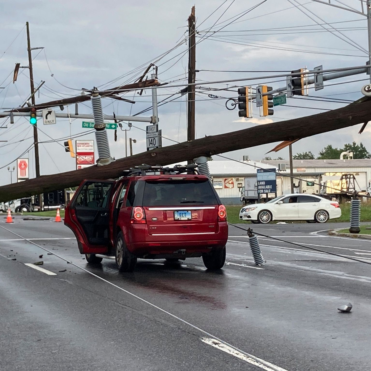 Ein umgestürzter Strommast auf einem Auto an einer Kreuzung in Westminster im Osten der USA. - Foto: Baltimore Sun Staff/The Baltimore Sun/AP/dpa