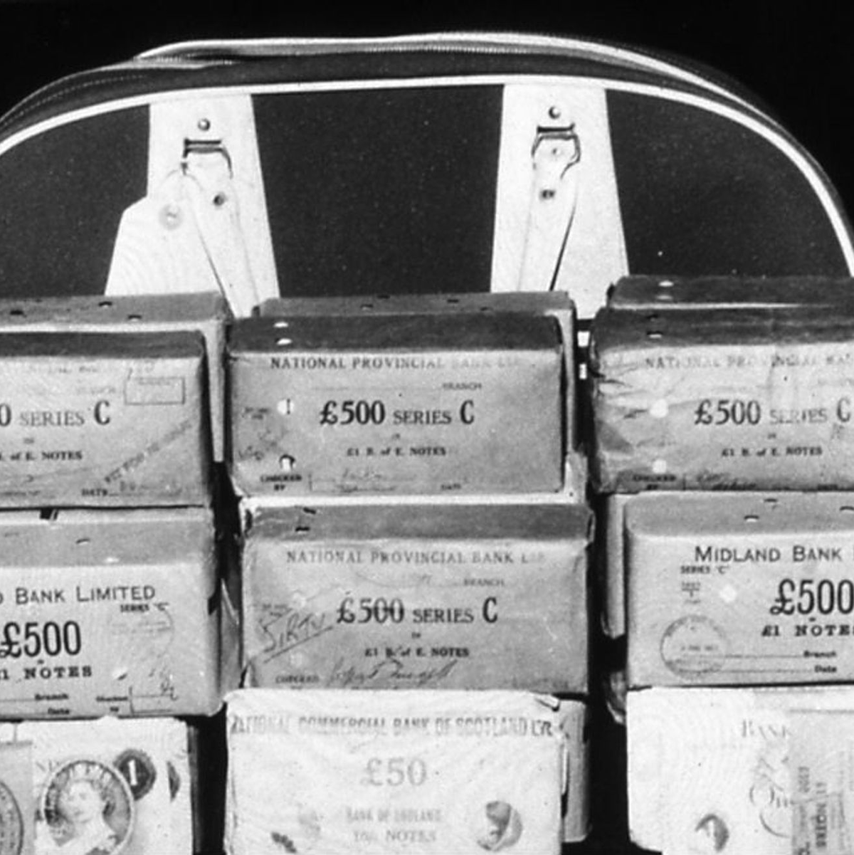 Sichergestellte Geldbündel vor einer Tasche von Mitgliedern der Bande, die an dem Überfall auf den Zug von Glasgow nach London beteiligt waren. - Foto: -/THAMES VALLEY POLICE FILE/EPA/dpa