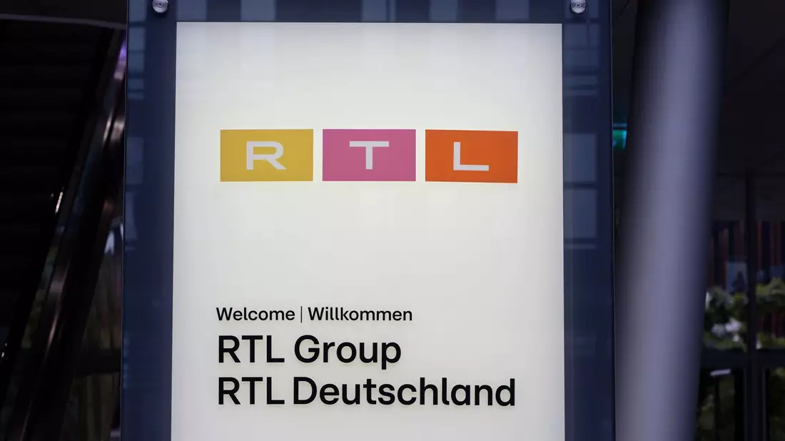 Ein Schild am Eingang des RTL-Gebäudes in Köln: Die RTL Group hat Halbjahreszahlen bekanntgegeben. - Bild: Henning Kaiser/dpa