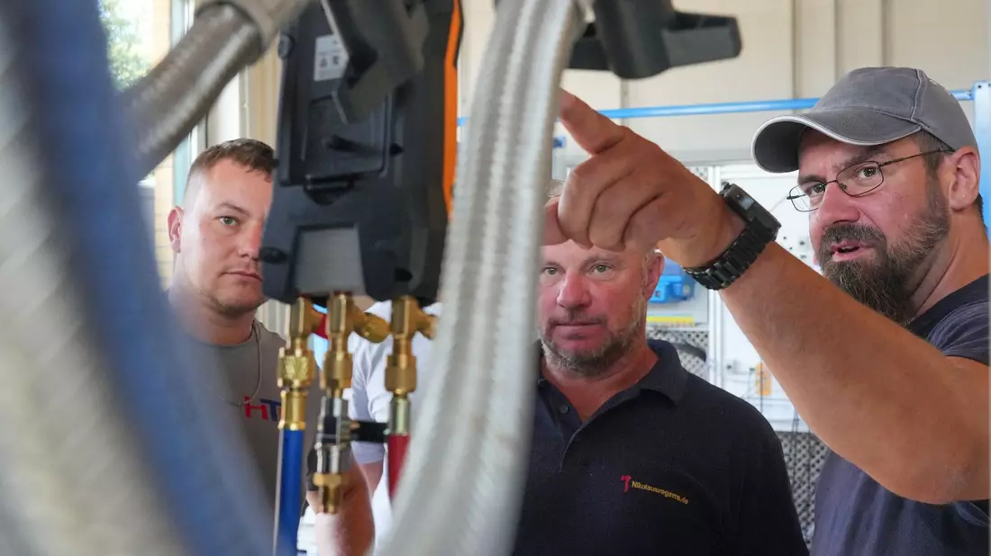 Meisterschüler Martin Scholz (r) unterhält sich mit Kollegen im Wärmepumpen-Labor auf dem Bildungs- und Innovationscampus der Handwerkskammer Potsdam (BIH). - Bild: Soeren Stache/dpa