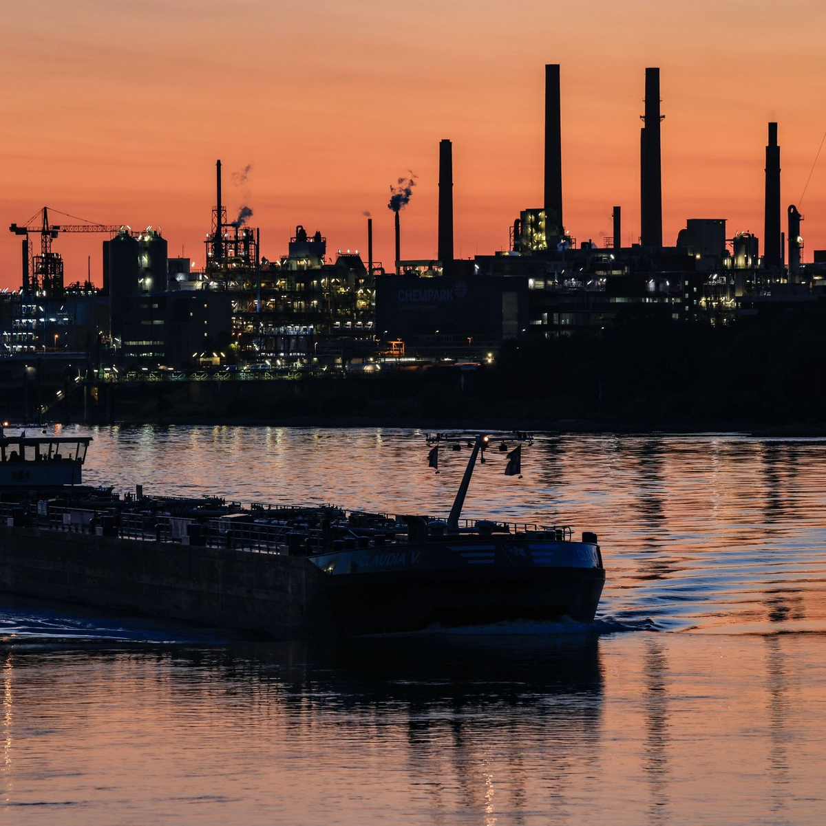 Ein Schiff fährt über den Rhein vor dem Bayer-Werk in Leverkusen. Der Konzern senkt seine Prognose auch für die Pharmasparte. - Foto: Oliver Berg/dpa