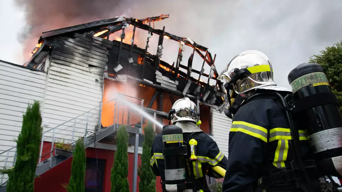 Feuerwehrleute löschen den Brand in der Ferienunterkunft in Ostfrankreich. - Bild: Patrick Kerber/dpa