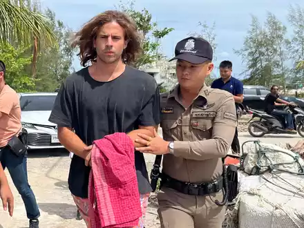 Ein thailändischer Polizist mit dem verdächtigen Spanier, der den Mord an dem Chirurgen gestanden hat. - Foto: Somkeat Ruksaman/AP/dpa