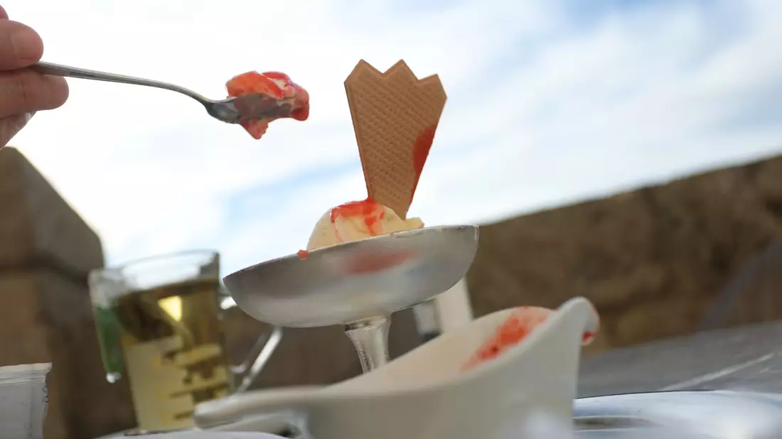 Eine Frau isst ein Eis. Auch bei reduzierter Mehwertsteuer verzichten viele Kundinnen und Kunden vor dem Hintergrund der aktuellen Konjunkturflaute auf einen Café-Besuch. - Bild: Karl-Josef Hildenbrand/dpa