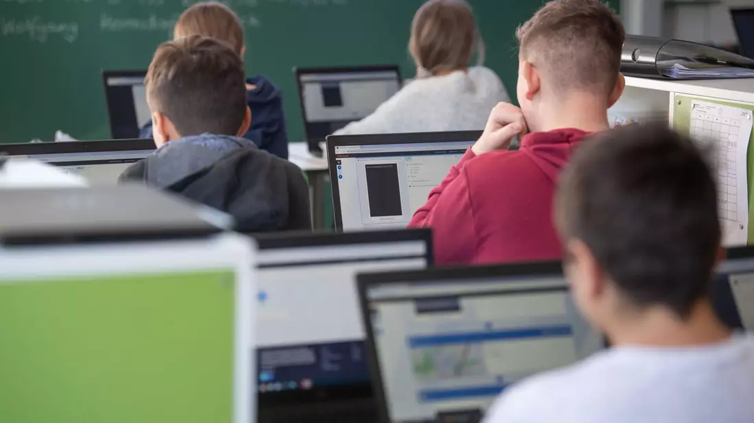 Schülerinnen und Schüler nehmen im Klassenzimmer einer 9. Klasse am Unterricht mit Hilfe von Laptops und Tablets teil. - Bild: Marijan Murat/dpa