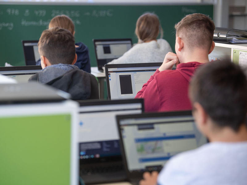 Schülerinnen und Schüler nehmen im Klassenzimmer einer 9. Klasse am Unterricht mit Hilfe von Laptops und Tablets teil. - Foto: Marijan Murat/dpa