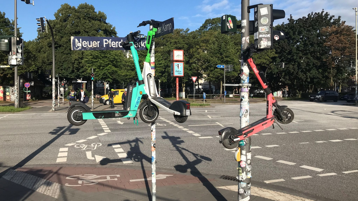Drei E-Scooter hängen an Masten im Hamburger Stadtteil St. Pauli. - Foto: Stefan Flomm/dpa