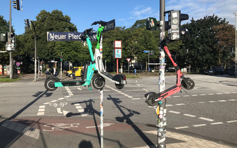 Drei E-Scooter hängen an Masten im Hamburger Stadtteil St. Pauli. - Foto: Stefan Flomm/dpa