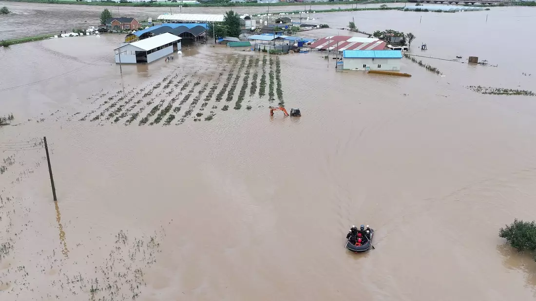 Rettungskräfte suchen auf einem Boot nach vermissten Personen im Hochwasser, nachdem der Tropensturm «Khanun» auf Land getroffen ist. - Bild: Yun Kwan-shick/Yonhap/AP/dpa