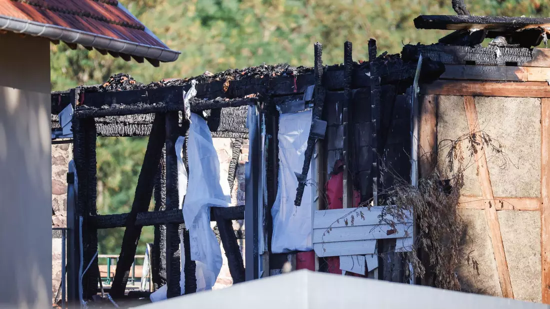 Nach dem Brand in einer Ferienunterkunft mit mehreren Toten im Elsass ermitteln die Behörden weiter. - Bild: Philipp von Ditfurth/dpa