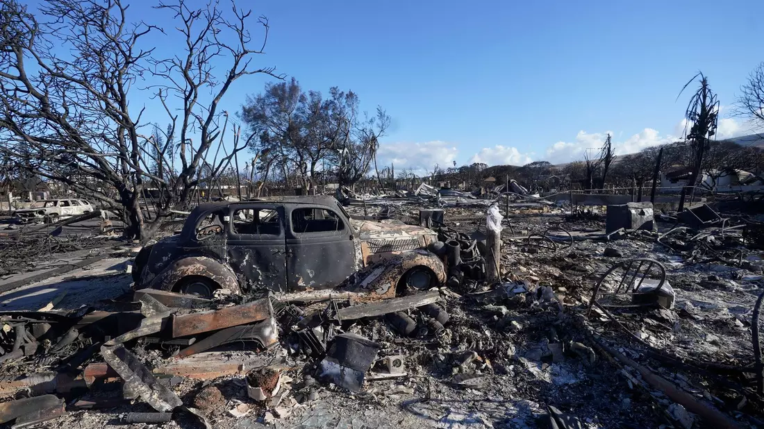 Ein ausgebranntes Auto steht mitten in einem völlig zerstörten Gebiet der Kleinstadt Lahaina. - Bild: Rick Bowmer/AP