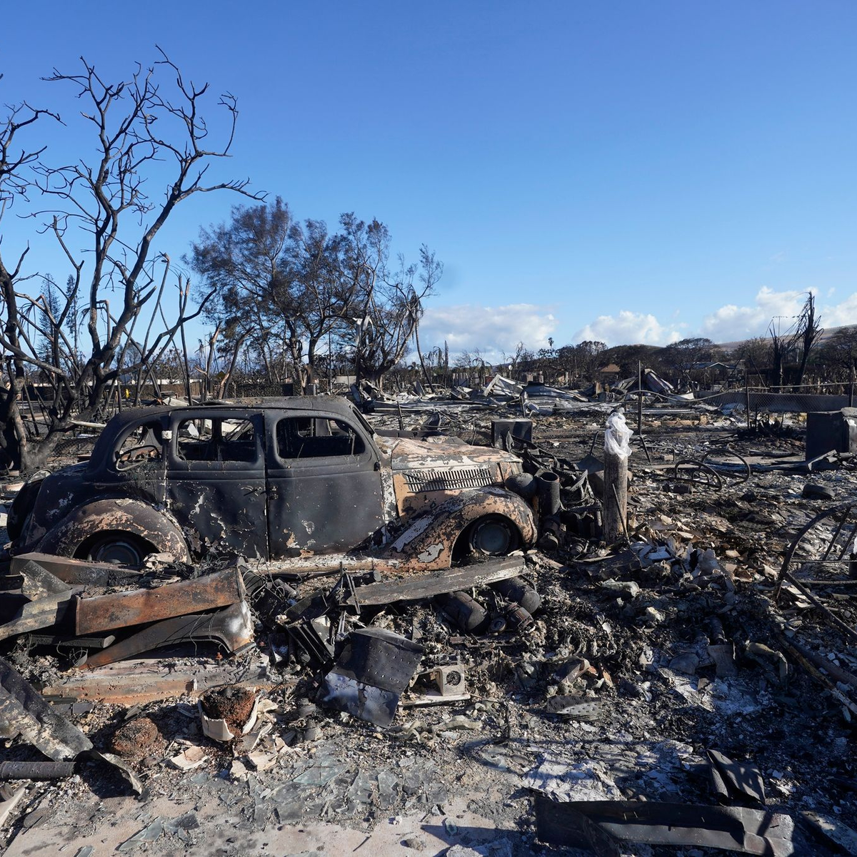 Ein ausgebranntes Auto steht mitten in einem völlig zerstörten Gebiet der Kleinstadt Lahaina. - Foto: Rick Bowmer/AP