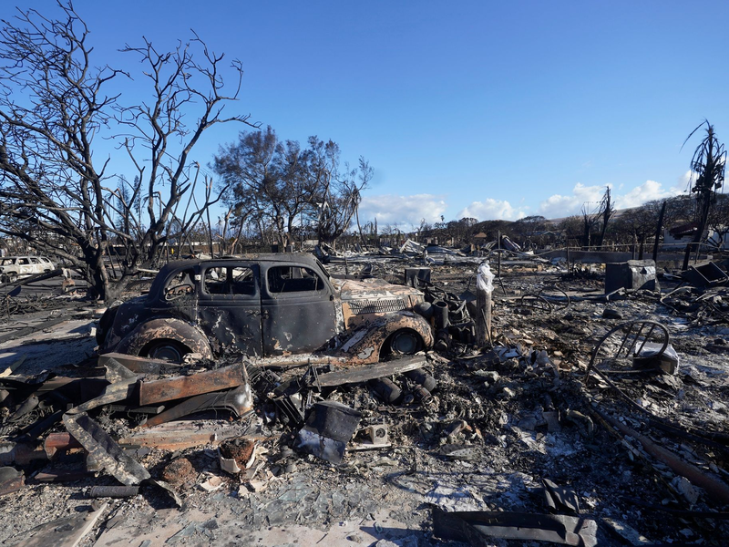 Ein ausgebranntes Auto steht mitten in einem völlig zerstörten Gebiet der Kleinstadt Lahaina. - Foto: Rick Bowmer/AP