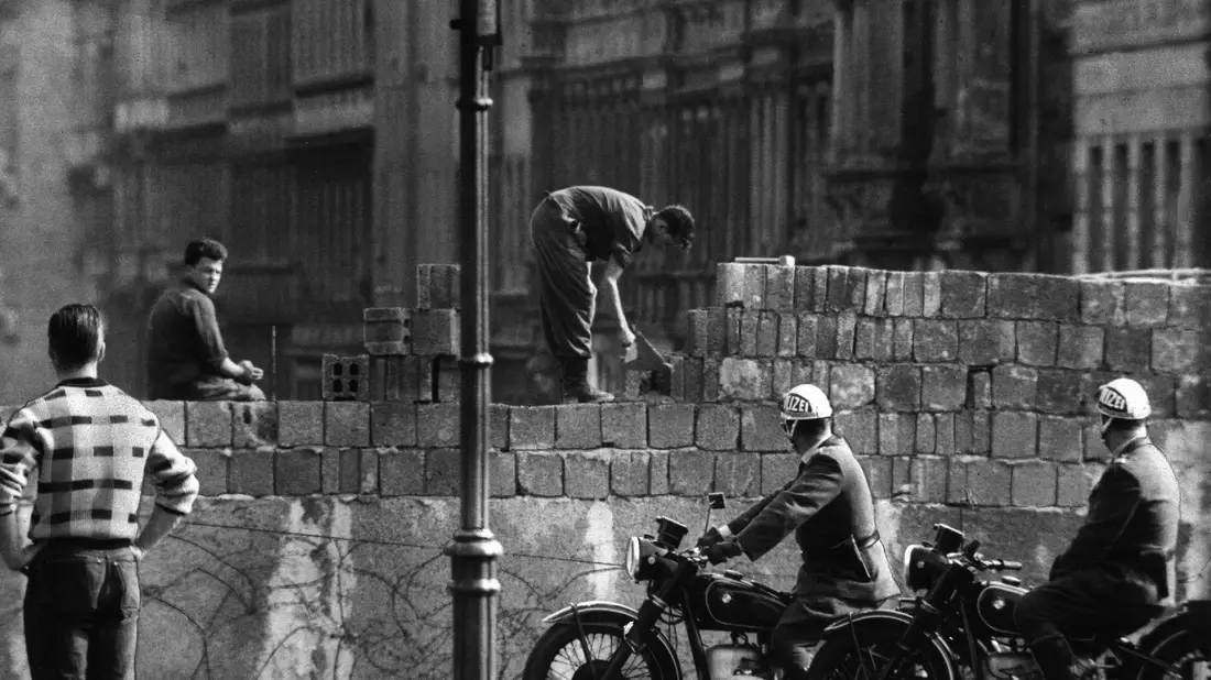Arbeiter erhöhen die Sektorensperre an der Bernauer Straße in Berlin. Mit dem Bau am 13. August wurde vor 62 Jahren begonnen. - Bild: dpa