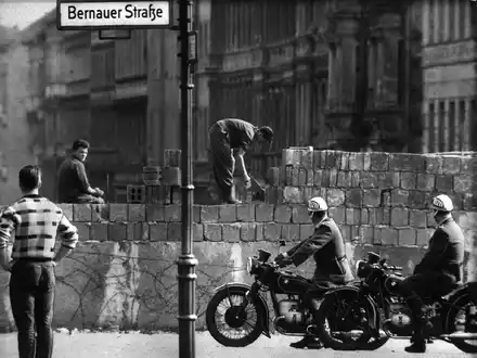 Arbeiter erhöhen die Sektorensperre an der Bernauer Straße in Berlin. Mit dem Bau am 13. August wurde vor 62 Jahren begonnen. - Foto: dpa