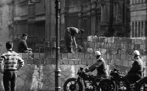 Arbeiter erhöhen die Sektorensperre an der Bernauer Straße in Berlin. Mit dem Bau am 13. August wurde vor 62 Jahren begonnen. - Foto: dpa