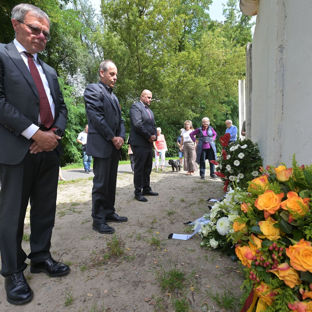 Potsdams Bürgermeister Burkhard Exner (SPD, l-r), Groß Glienickes Ortsvorsteher Winfried Sträter und Berlins Spandaus Bürgermeister Frank Ewig (CDU) gedenken an einem alten Stück Berliner Mauer, das ein Teil der Mauergedenkstätte im Gutspark Groß Glienicke ist, an den Mauerbau. - Foto: Michael Bahlo/dpa